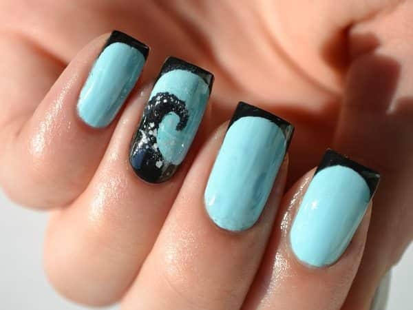 Ongles bleu clair avec des vagues noires et des pointes noires