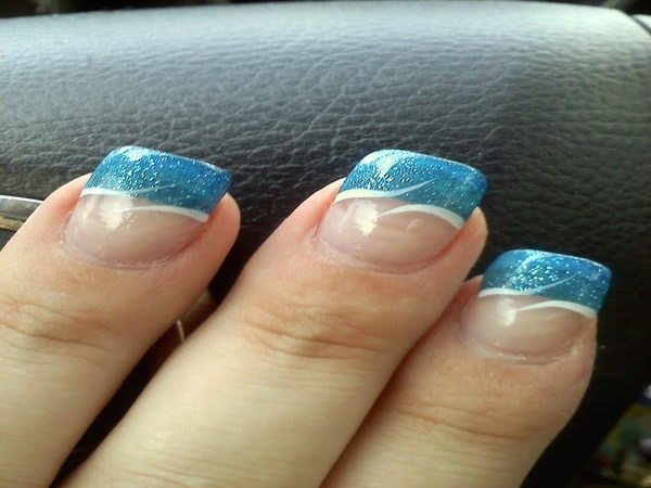 Ongles unis avec des pointes de paillettes bleues et des dessins de vagues