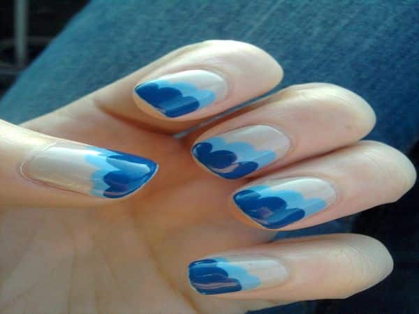 Ongles bronzés avec des motifs de vague bleu clair et bleu foncé
