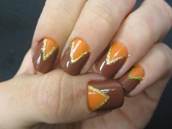 Ongles marron et orange avec des motifs triangulaires soulignés d'or