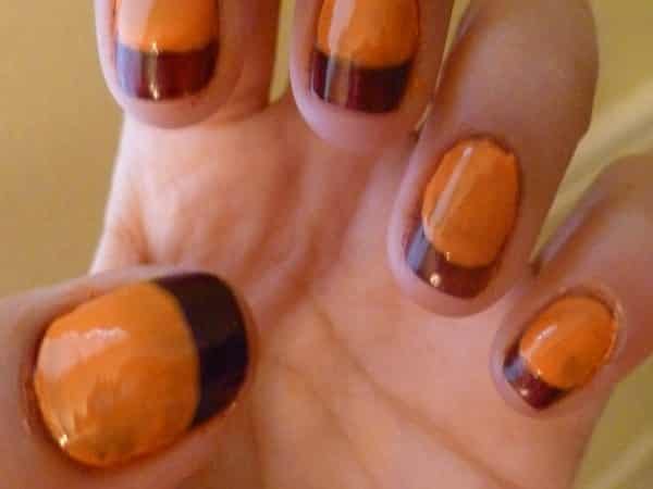 Ongles oranges avec des pointes brunes