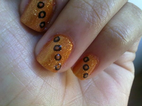 Ongles pailletés oranges à pois marrons et noirs