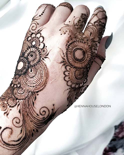 Belle main au henné avec des fleurs et des tourbillons