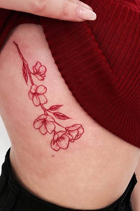 Tatouage de côte de fleur d'encre rouge