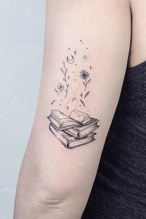 Pile de livres avec la conception de tatouage de fleurs