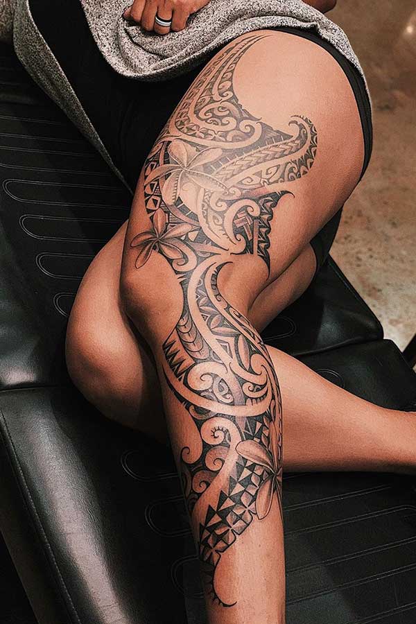 Beau tatouage tribal de jambe avec des fleurs