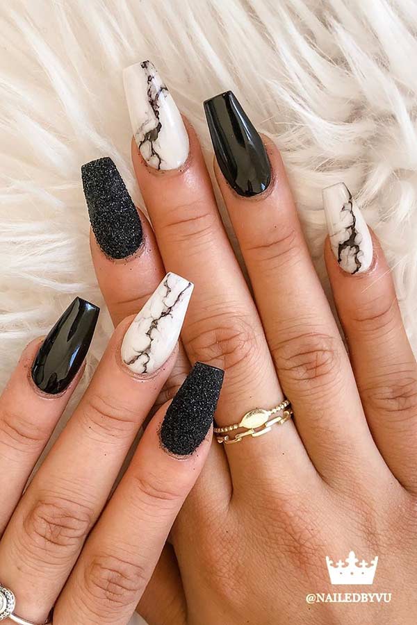 Ongles noirs avec un design en marbre blanc