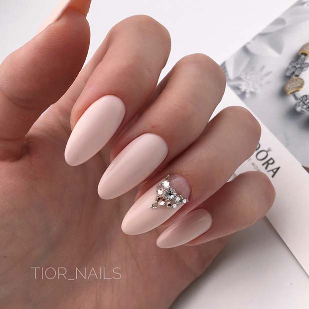 Ongles nude clair avec un ongle d'accent scintillant