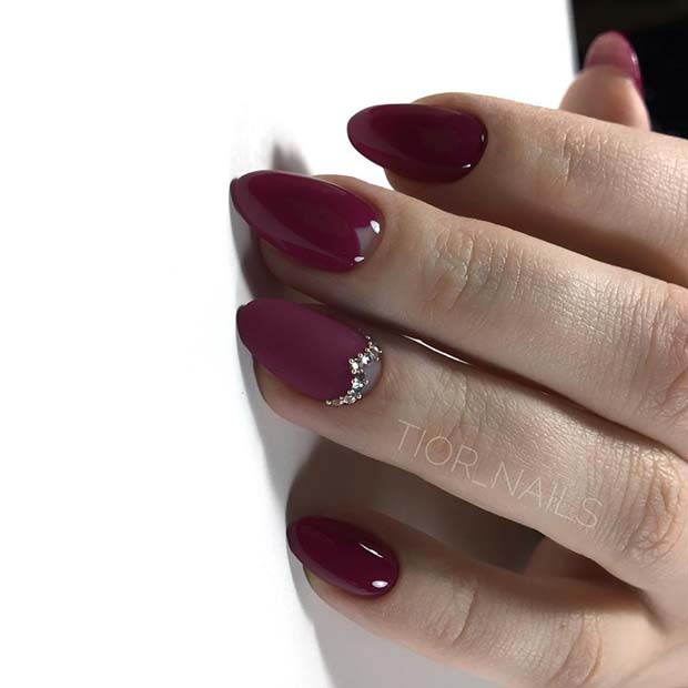 Ongles bordeaux avec pierres précieuses