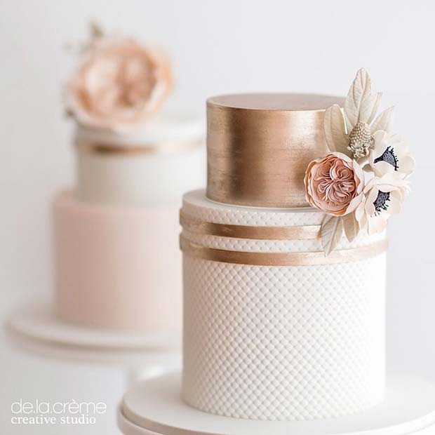 Gâteau de mariage en or rose avec des fleurs