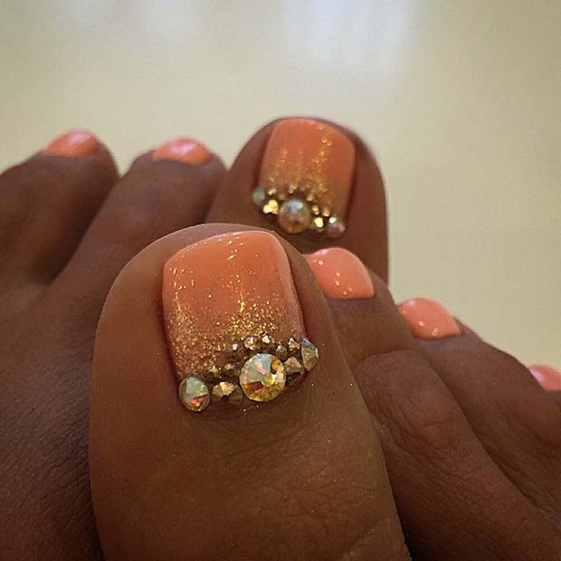 Conception d'ongle d'orteil orange avec des strass