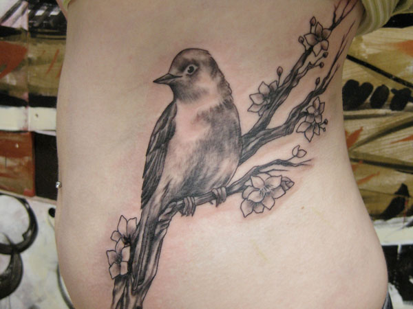 Nightingale που κάθεται σε ένα κλαδί τατουάζ