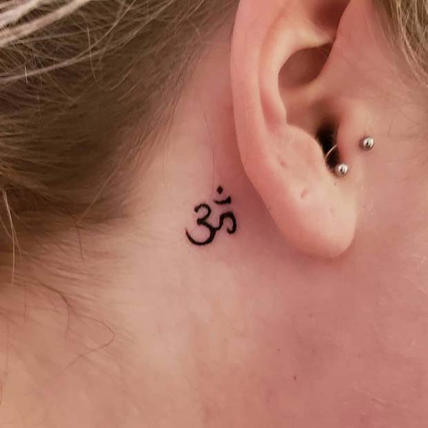 Om derrière l'oreille tatouage