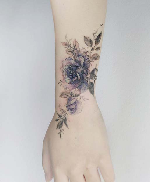 Beau tatouage au poignet de rose bleue