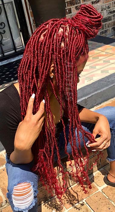 Longs faux locs rouges dans un chignon demi-haut