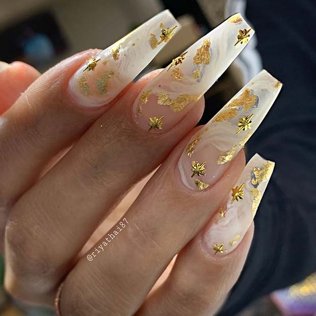 Ongles en marbre blanc avec feuille d'or et étoiles