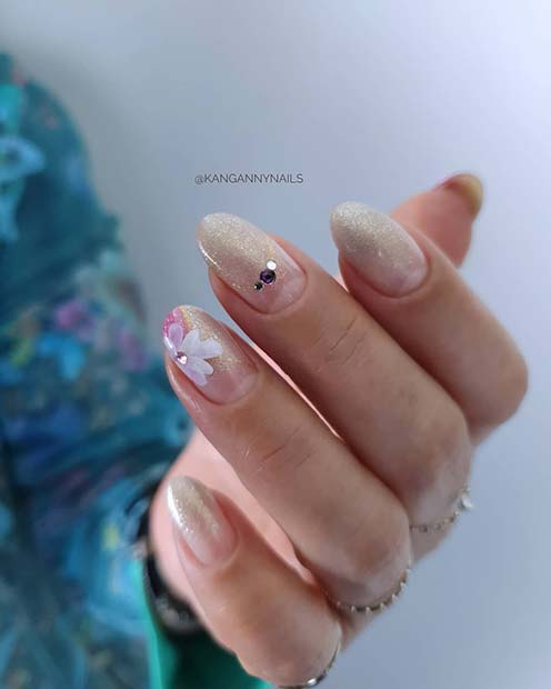 Ongles à paillettes dorées subtiles avec des fleurs