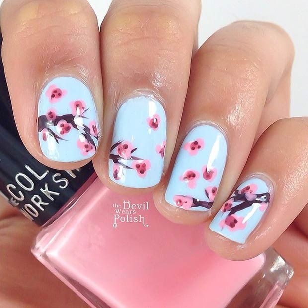 Ongles bleu clair avec des fleurs de cerisier