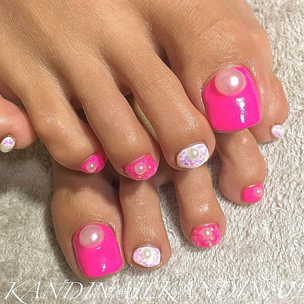 Ongles d'orteil roses avec des perles