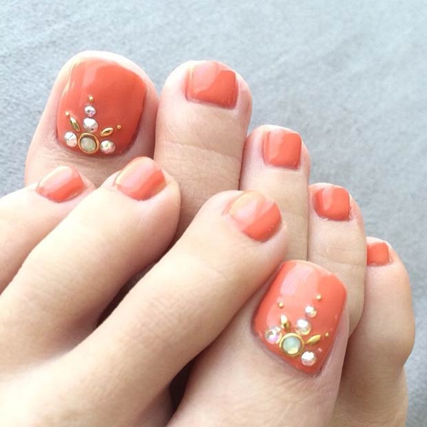 Ongles d'orteil orange avec strass