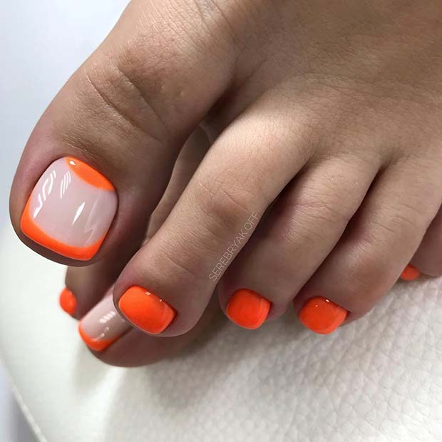Ongles d'orteils orange fluo avec ongle d'accent tendance