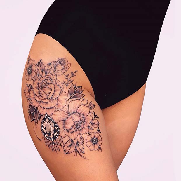 Λουλουδάτο τατουάζ μηρών με ένα τολμηρό κόσμημα