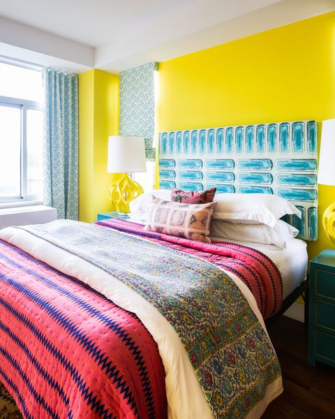 חדר שינה עם קירות צהובים ומצעים ורודים
