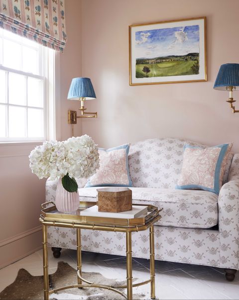 murs peints en rose, table basse dorée, appliques bleues