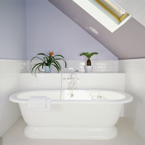 μπανιέρα κάτω από φεγγίτη σε σοφίτα μπάνιο με λιλά μοβ τοίχους