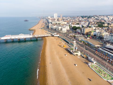 photo aérienne de la célèbre jetée de Brighton et de l'océan situés sur la côte sud de l'Angleterre au Royaume-Uni qui fait partie de la ville de Brighton et Hove, prise par une belle journée ensoleillée montrant les manèges forains