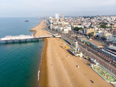 תצלום אוויר של מזח ברייטון המפורסם והאוקיינוס ​​הממוקם בחוף הדרומי של אנגליה בריטניה המהווה חלק מהעיר ברייטון והוב, שצולם ביום שמש בהיר המציג את רכיבות הירידים