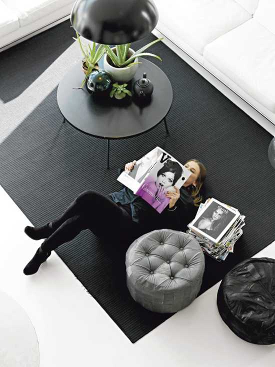 момиче със списание на пода, черен килим