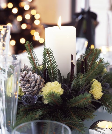 décorations de noël en noir et blanc avec de l'argent et du violet forsted pour la maison, table à manger avec pièce maîtresse en bougie faite de branches fraîchement coupées, de pommes de pin et d'oeillets