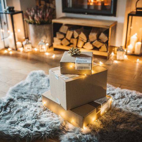 salon cosy intérieur hiver avec cheminée, cadeaux commandés en ligne et livrés attendre devant la cheminée