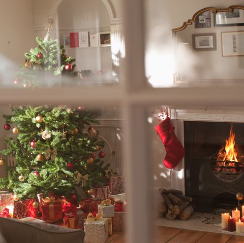 arbre de noël dans le salon derrière la fenêtre