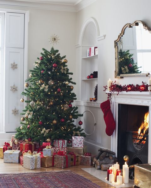 עץ חג המולד מוקף במתנות ליד האח