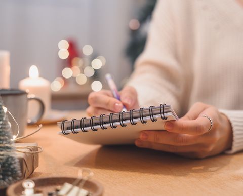 objectifs plans faire et liste de souhaits pour le nouvel an concept de noël écrit dans un ordinateur portable woman hand holding pen sur le bloc-notes à la maison pendant les vacances d'hiver noël