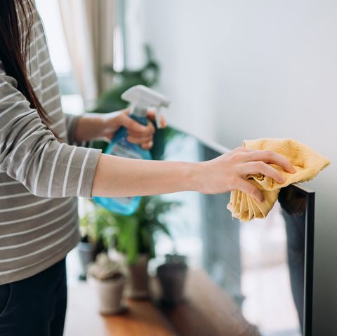 photo recadrée d'une jeune femme nettoyant la surface d'un téléviseur avec un spray nettoyant et un chiffon antistatique à la maison pendant la journée