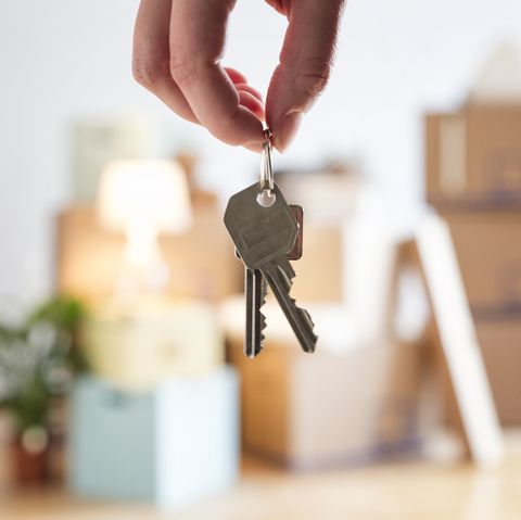 Close up of woman holding house key in new home