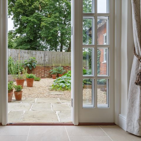 נוף לגינה מבפנים עם דלתות צרפתיות המובילות לגינת מטבח בחצר