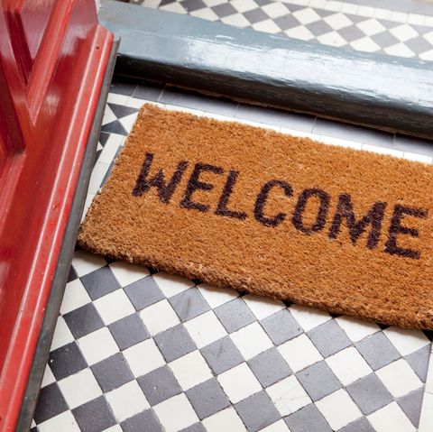 porte d'entrée rouge ouverte avec tapis de bienvenue