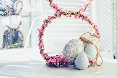 Oeufs de Pâques avec des bourgeons roses sur la table