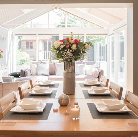 להישען להרחבה, מבט פנימי כללי של סועד מטבח הנפתח לתוך חממה המציגה שולחן אוכל ערוך בתוך בית