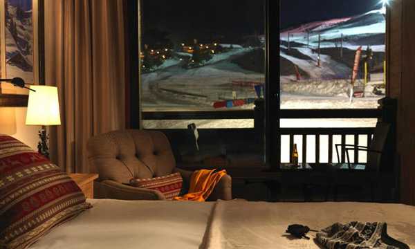 изглед през прозореца към планините и ски пистата през нощта