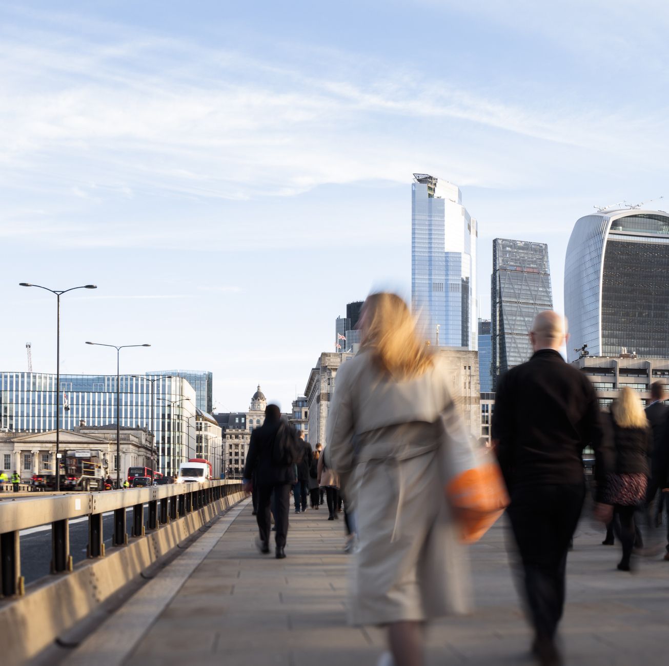 בריטניה, לונדון, מבט לאחור של אנשי עסקים ונשים שהולכים לעבודה דרך גשר לונדון עם נוף לרובע הפיננסי
