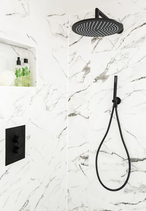 pomme de douche et raccords noirs sur un mur carrelé effet marbredouche la nouvelle douche noire dissimulée a utilisé la tuyauterie existante en boîte pour une finition élégante et épurée
