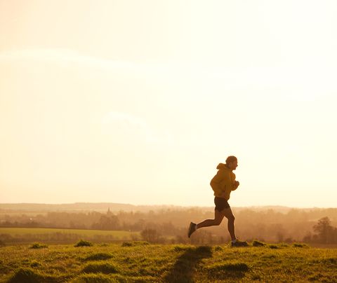 jogger courant sur la colline au coucher du soleil