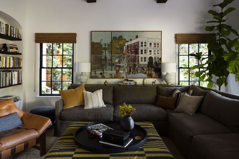 καθιστικό, πράσινος καναπές, δερμάτινη καρέκλα, κίτρινο μαξιλάρι, λευκοί τοίχοι