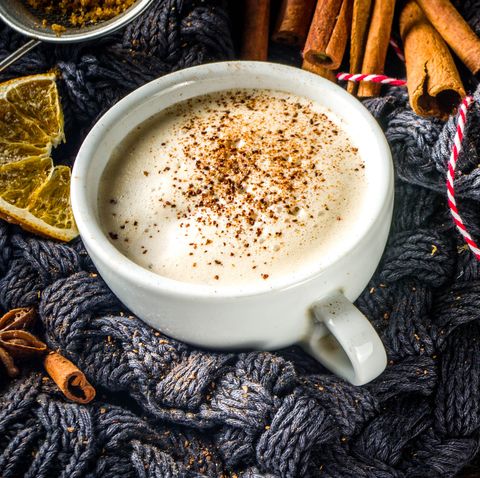 boisson chaude sucrée d'automne, rhum au beurre chai, tarte à la citrouille ou café au lait aux épices de citrouille fond d'automne confortable avec tasse à latte traditionnelle, épices et vieux pull, sur fond de bois rustique