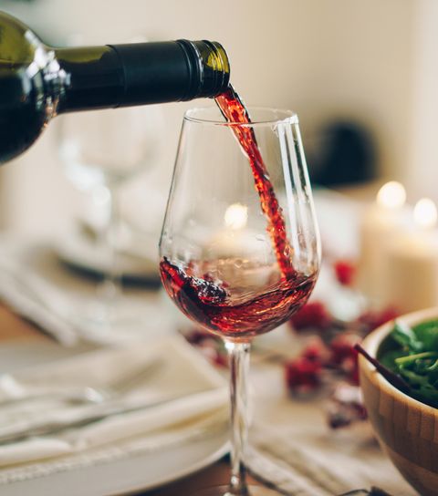 κόκκινο κρασί που χύνεται στο ποτήρι στο τραπέζι